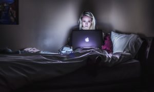woman using computer in bed